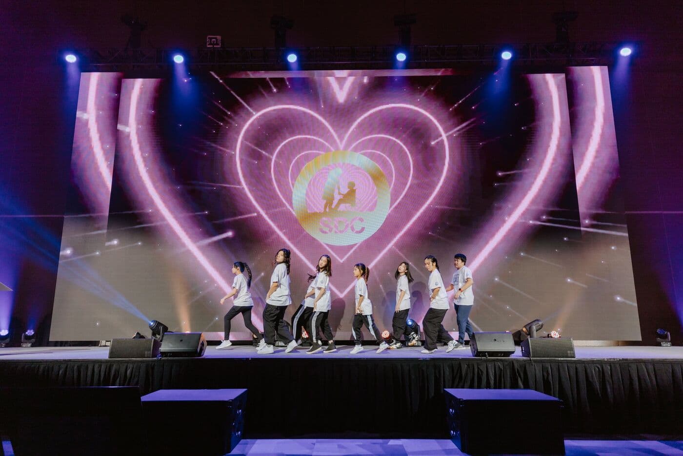 SDC youth dance team performing in front of a heart-shaped light display